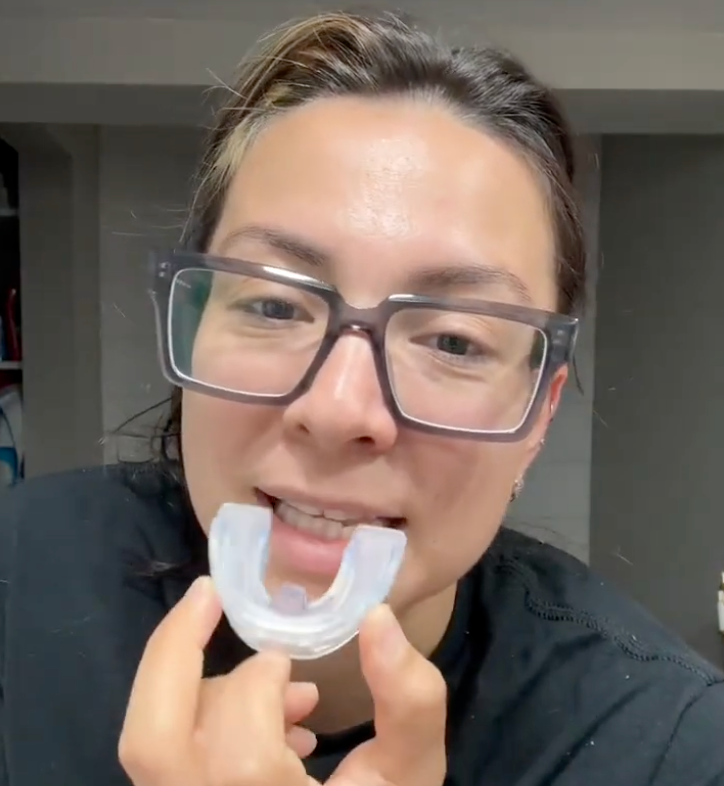 Woman placing her Reviv mouthguard in her mouth